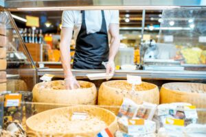 Man packing cheese in the shop
